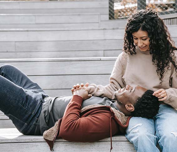 A black man rests his head on a woman's lap