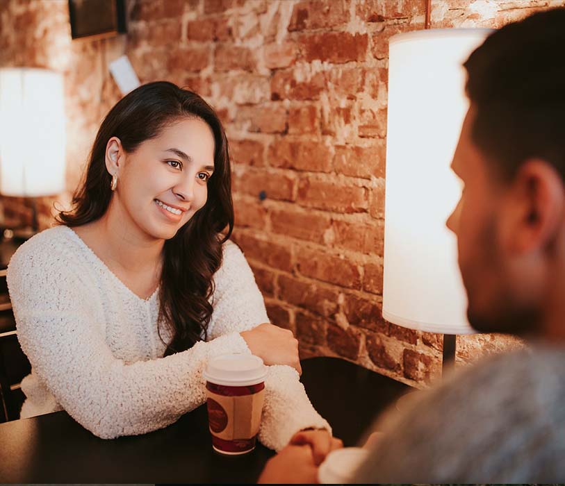 A couple sitting in cafeteria with coffee cups