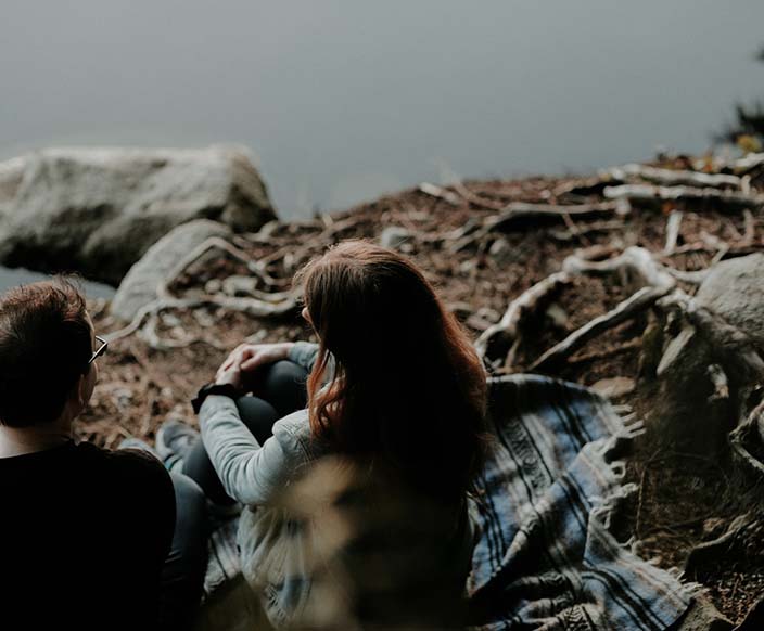 A couple sitting near the body of water