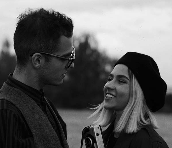 A grayscale photo of man and woman smiling