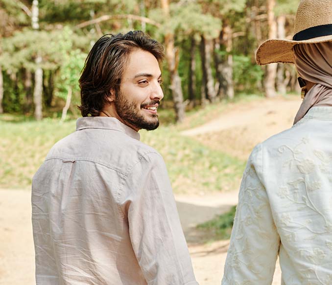 A man and a woman are holding hands and looking into each other's eyes.