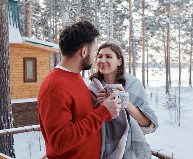 A man and a woman holding a cup of drink on a winter day