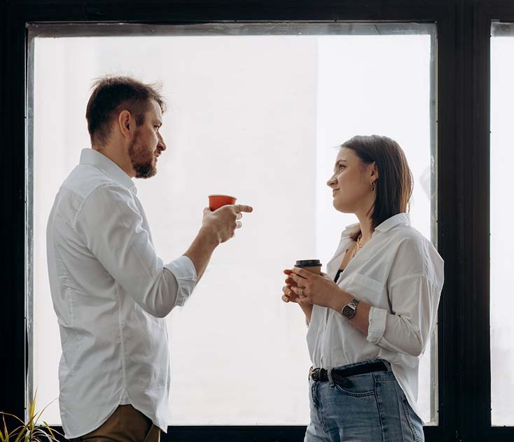 A man and woman talking wearing white long sleeve