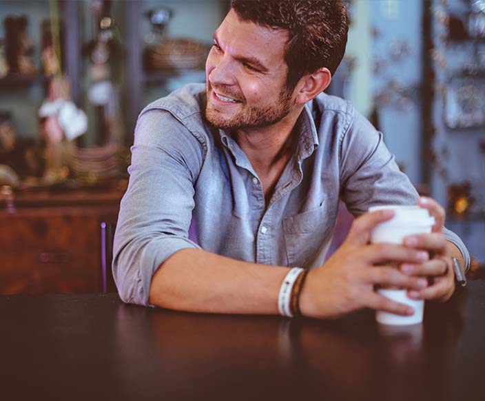 A man holding a cup on a table