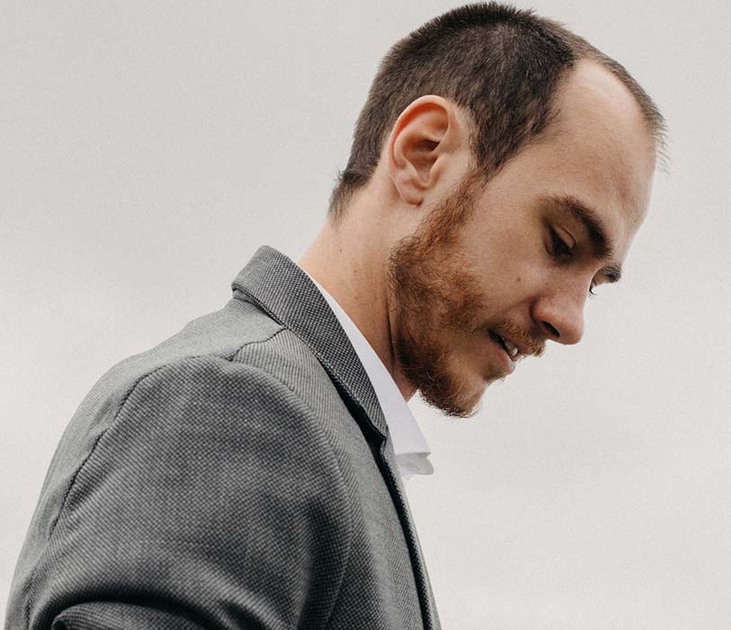 A man in a formal dress against cloudy sky