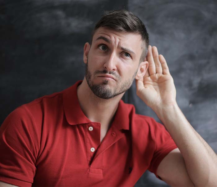 A man in red polo shirt sitting near chalkboard