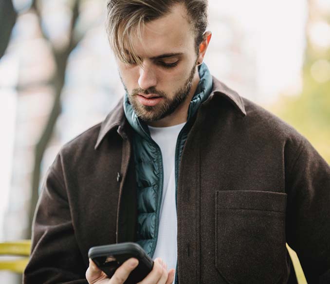 A man looking at smartphone screen in a park
