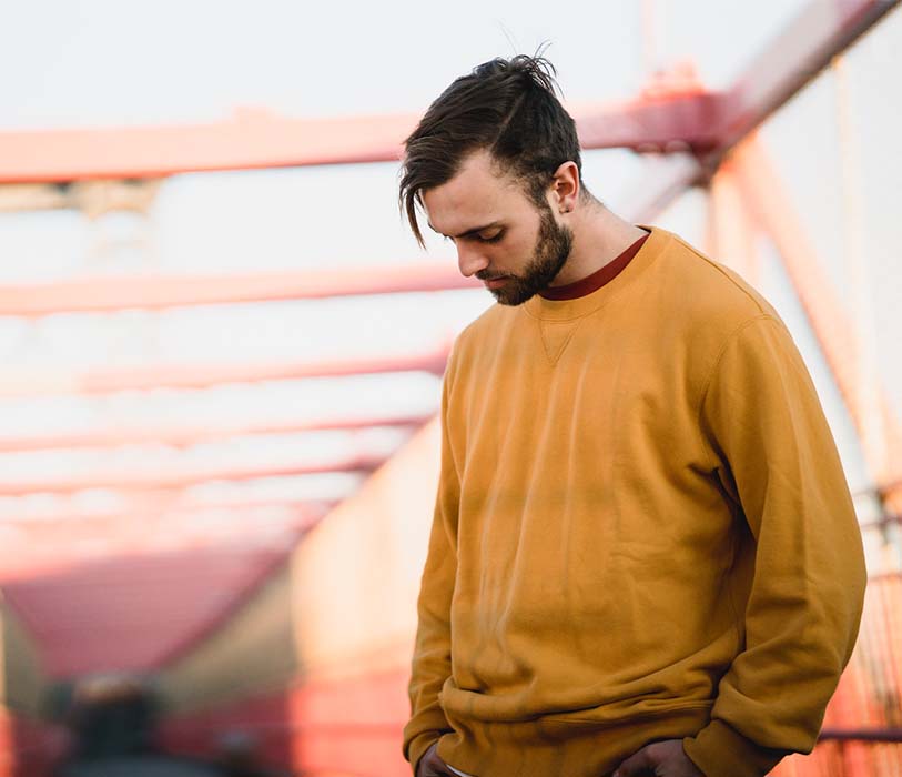 A man wearing yellow cloths on urban bridge