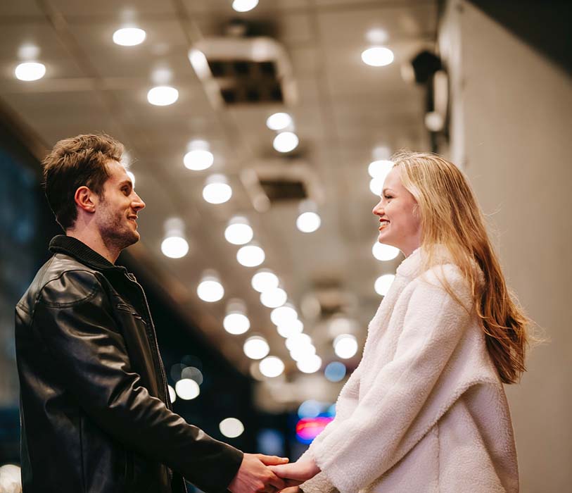 A smilling couple standing in a hall of subway