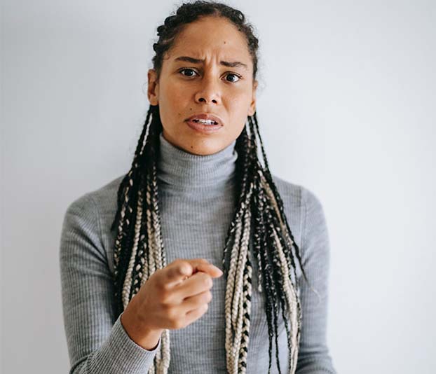 A woman frowning face and pointing at camera