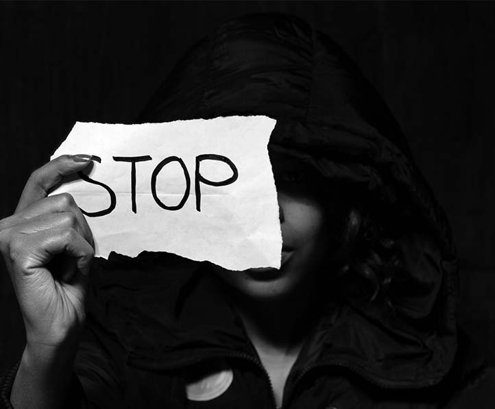 A woman holding a paper with the word stop