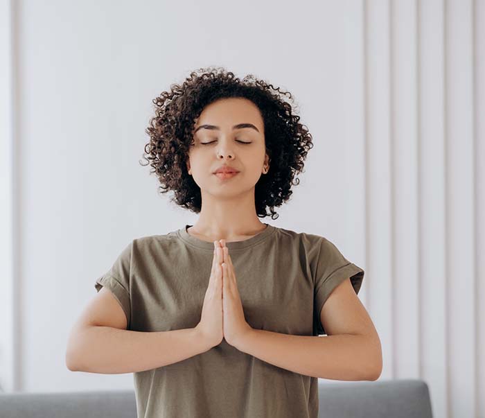 A woman in gray crew neck t-shirt in a yoga position