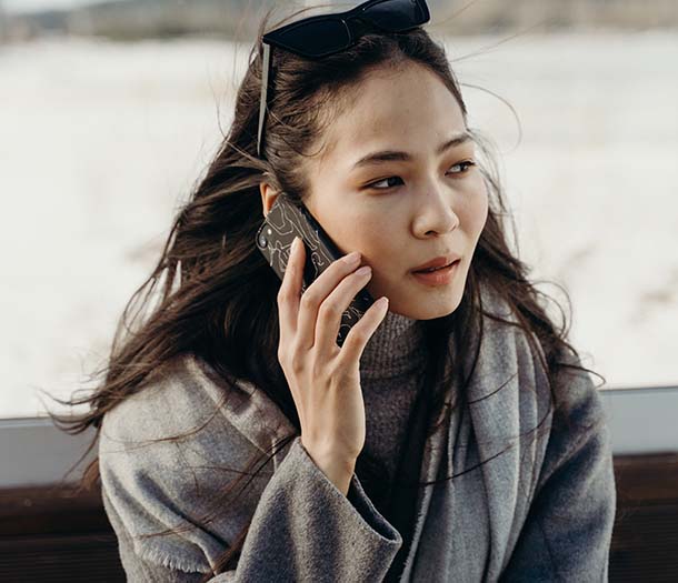 A woman in gray sweater talking on the phone
