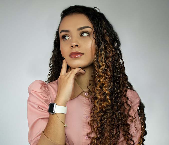 A woman with curly hair thinking