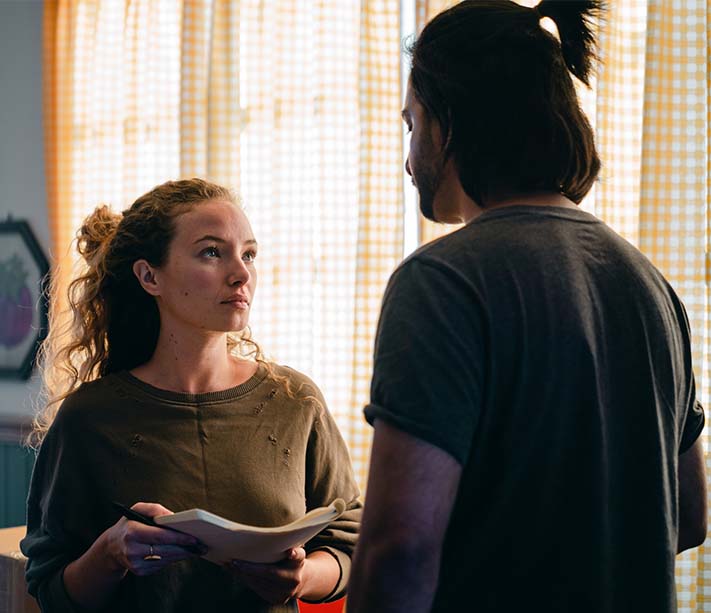 A woman with notebook looking at boyfriend