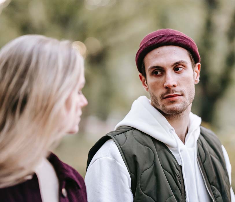 A young stylish couple talking with each other in park