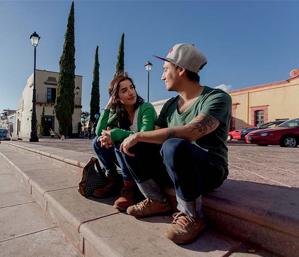 Photo of a couple holding hands while sitting on concrete steps