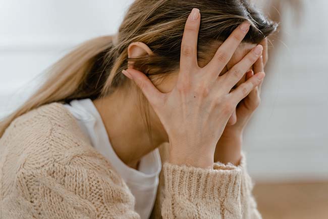 a woman covering her face with her hands