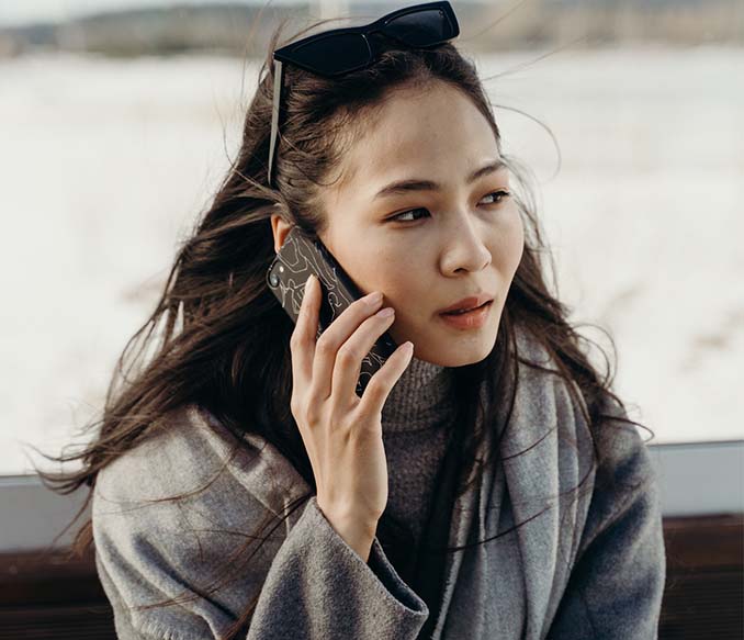 a woman in gray sweater talking on the phone