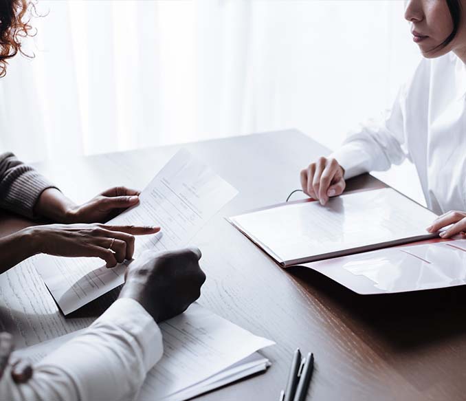 couple sitting at table with documents laying on it