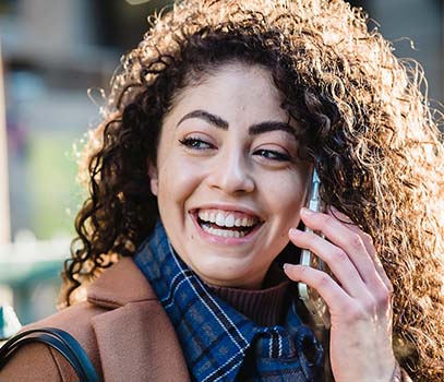 delighted woman having phone call on street