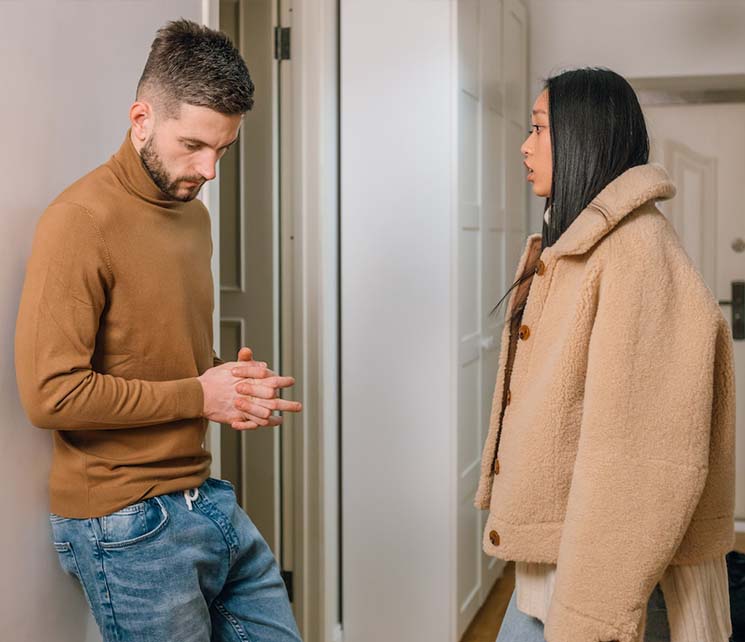 photo of a woman talking to a man in a brown shirt