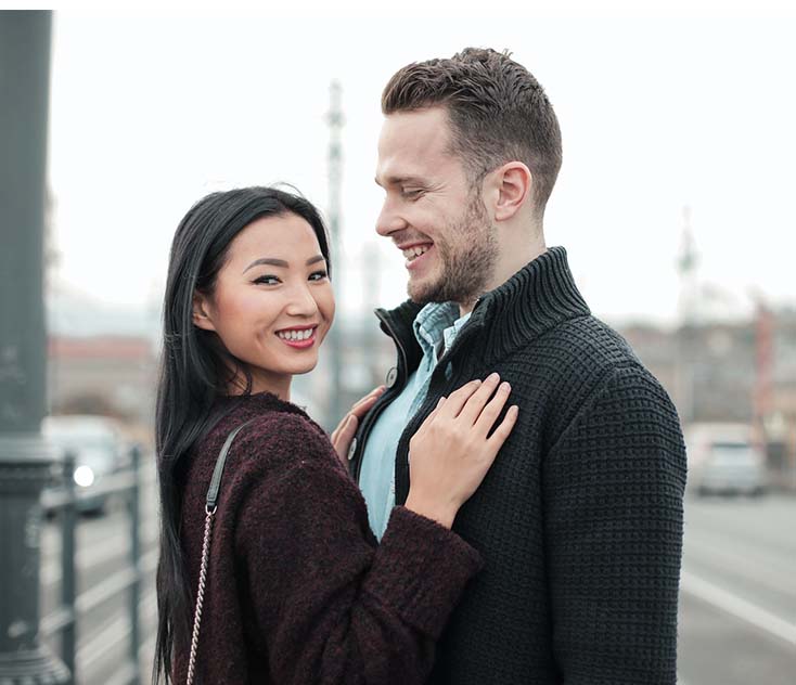 selective focus photo of smiling couple standing next to each other