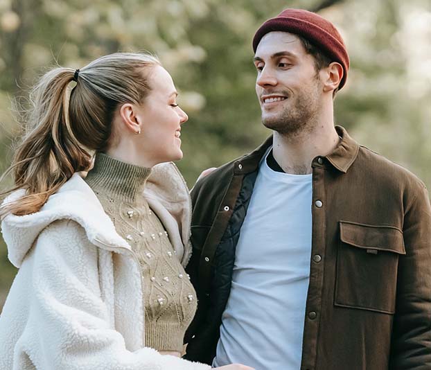 smiling young couple standing in park during romantic date