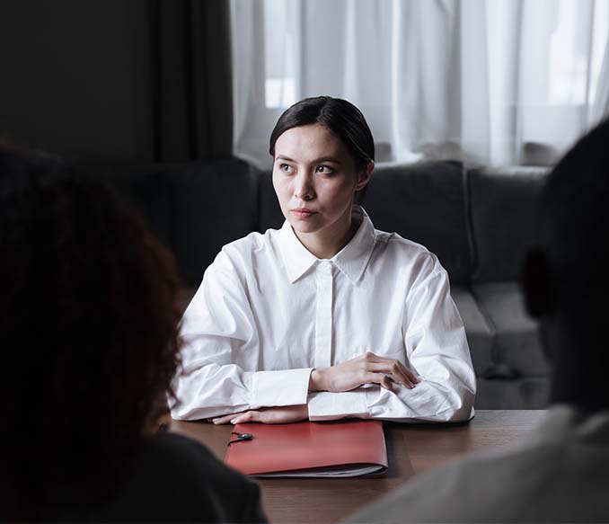 social worker sitting at table with documents folder in front of a girl