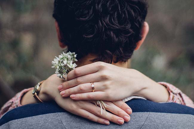 a woman's hand on a man's shoulder in close up photo